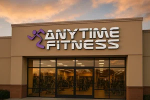 Exterior view of an Anytime Fitness franchise gym with modern design and sunset sky