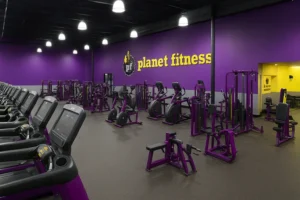 Planet Fitness Franchise gym interior with purple and yellow equipment layout.